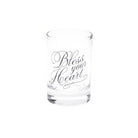A clear glass shot glass with the phrase 'Bless your Heart' printed in elegant black cursive script on the front, set against a plain white background.