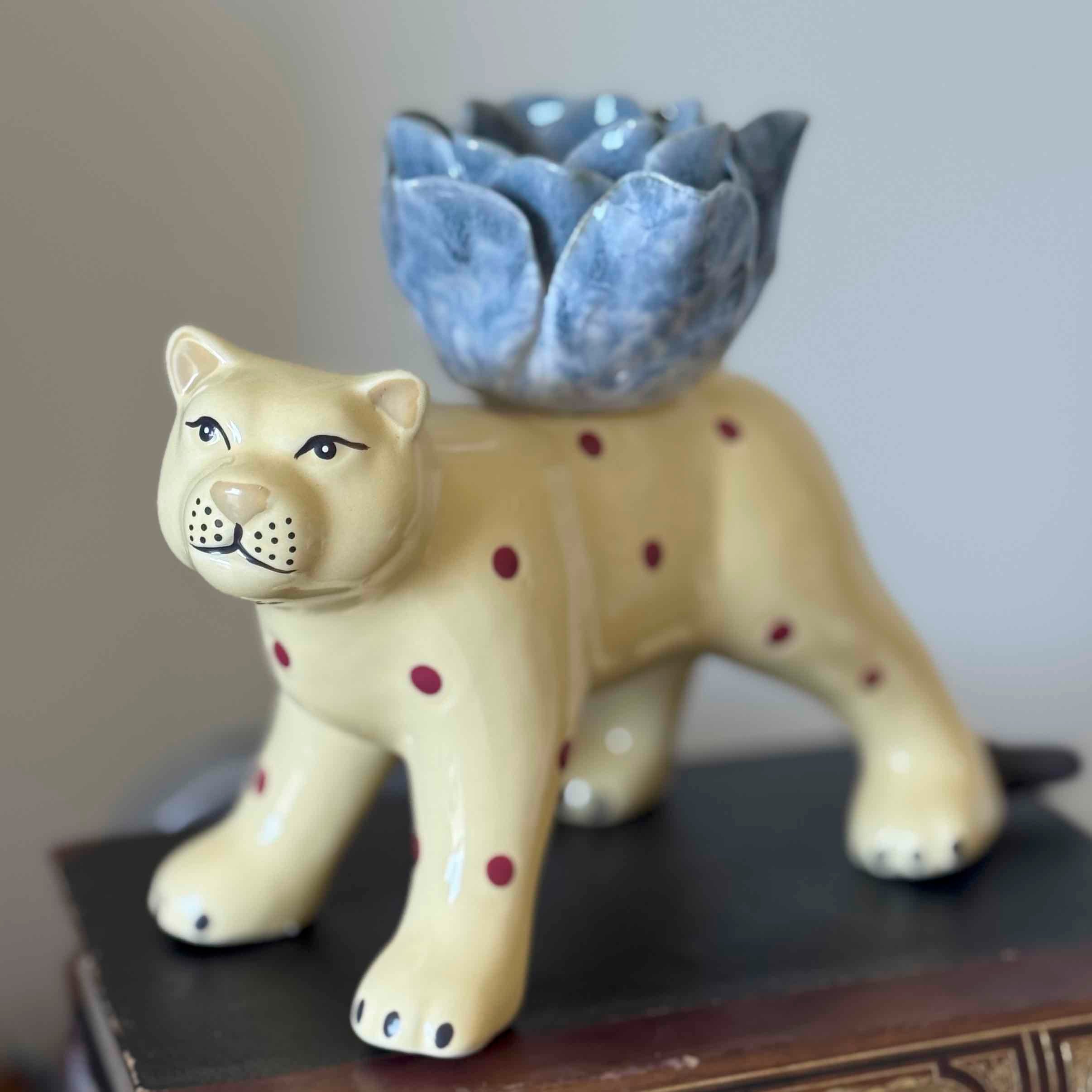 Ceramic lion planter with a blue succulent on a wooden surface