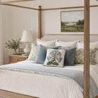 Neatly made bed with decorative pillows and a lamp in a bedroom setting.