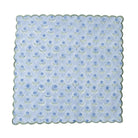 Scalloped-edged fabric swatch with blue floral pattern on a light blue background