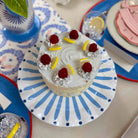Decorative cake with raspberries and lemon slices on a blue and white plate