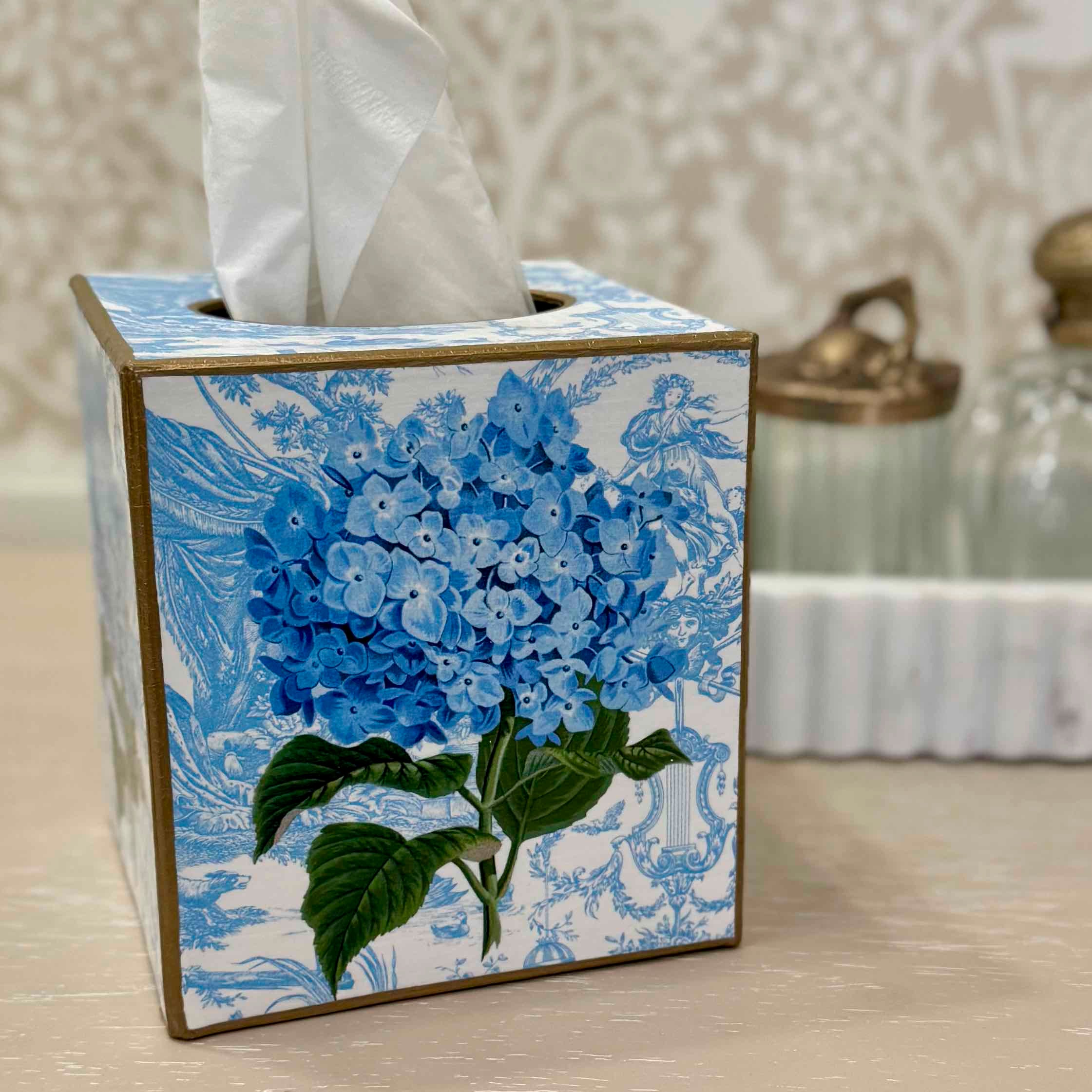 Tissue box cover with blue floral design on a neutral background