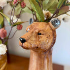 Wooden bear figurine with a blurred floral background
