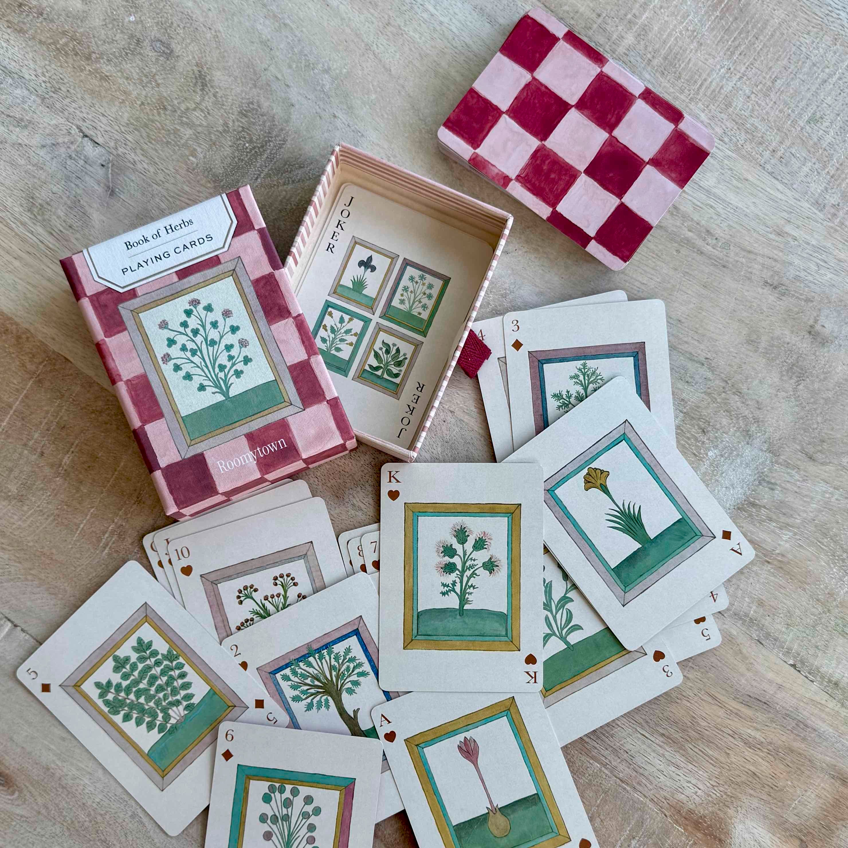 Playing cards with botanical designs on a wooden surface