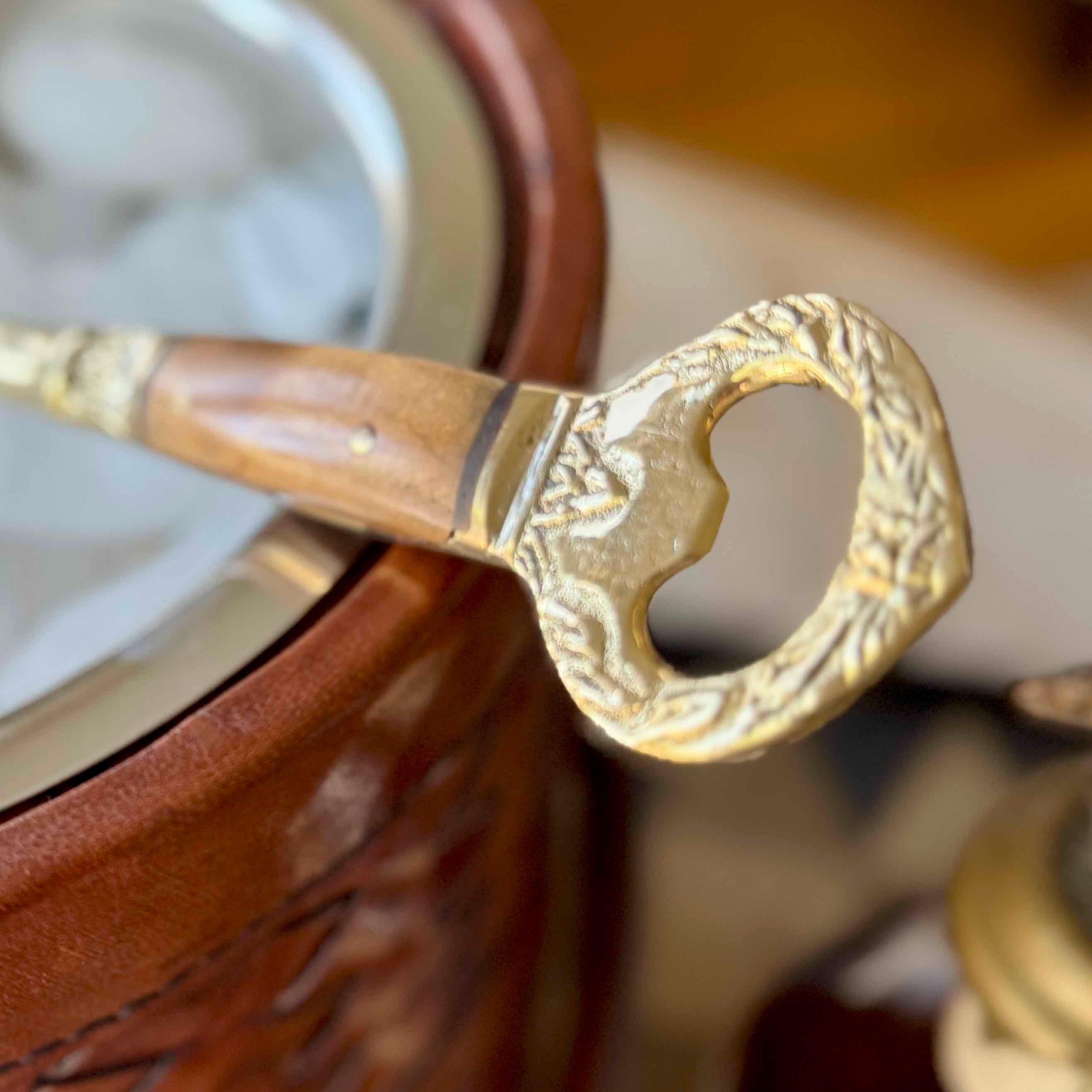Close-up of a gold bottle opener on a wooden surface