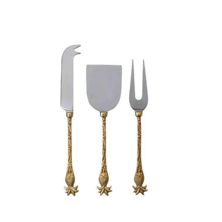 Set of three decorative cheese tools with gold handles on a white background