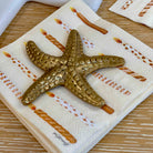 Decorative starfish on a patterned napkin with a wooden surface background