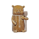 Bear-shaped container holding honey on a white background