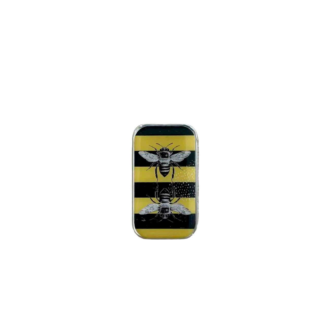 A rectangular metal lighter with a yellow and black striped design featuring two detailed bumblebee illustrations, resting on a light-colored wooden surface.
