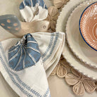 Decorative table setting with patterned napkins and plates.