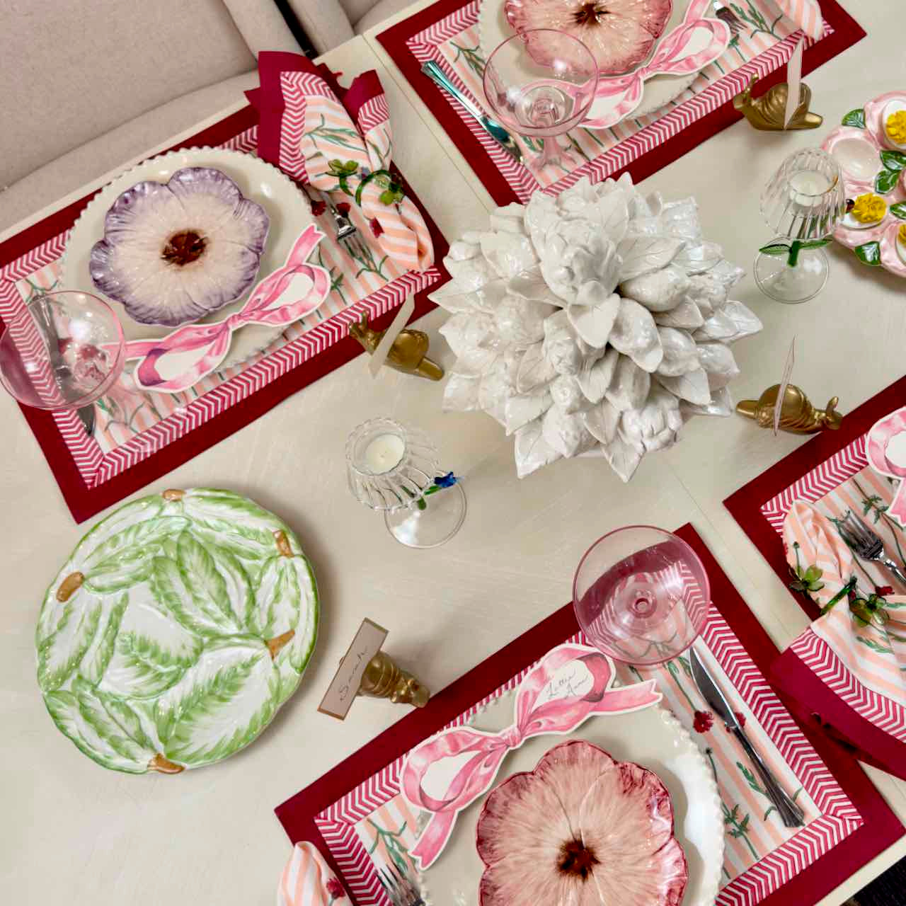 Decorative table setting with floral-themed placemats and cutlery on a light surface.