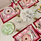 Decorative table setting with floral-themed placemats and cutlery on a light surface.