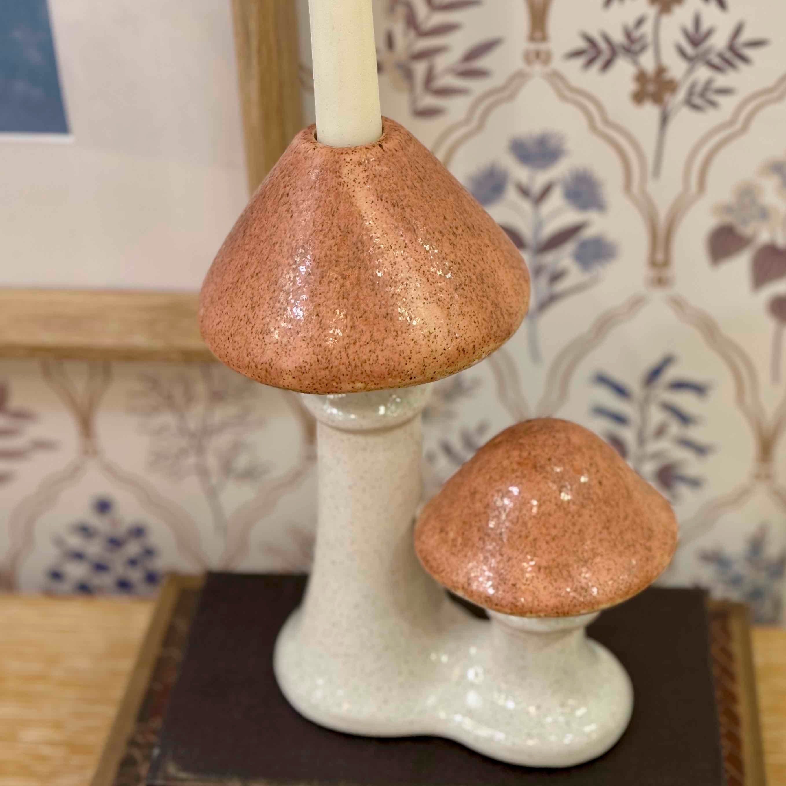 Ceramic mushroom candle holder on a surface with a patterned background