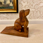 Wooden rabbit sculpture on a stand with a decorative background