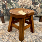 Wooden stool with leaf design on a patterned rug