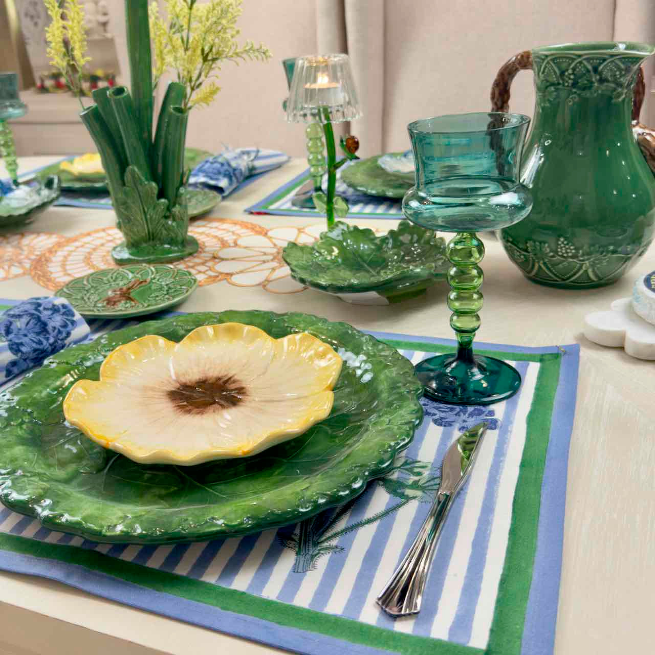 Green and yellow ceramic plate with a decorative setting on a table.