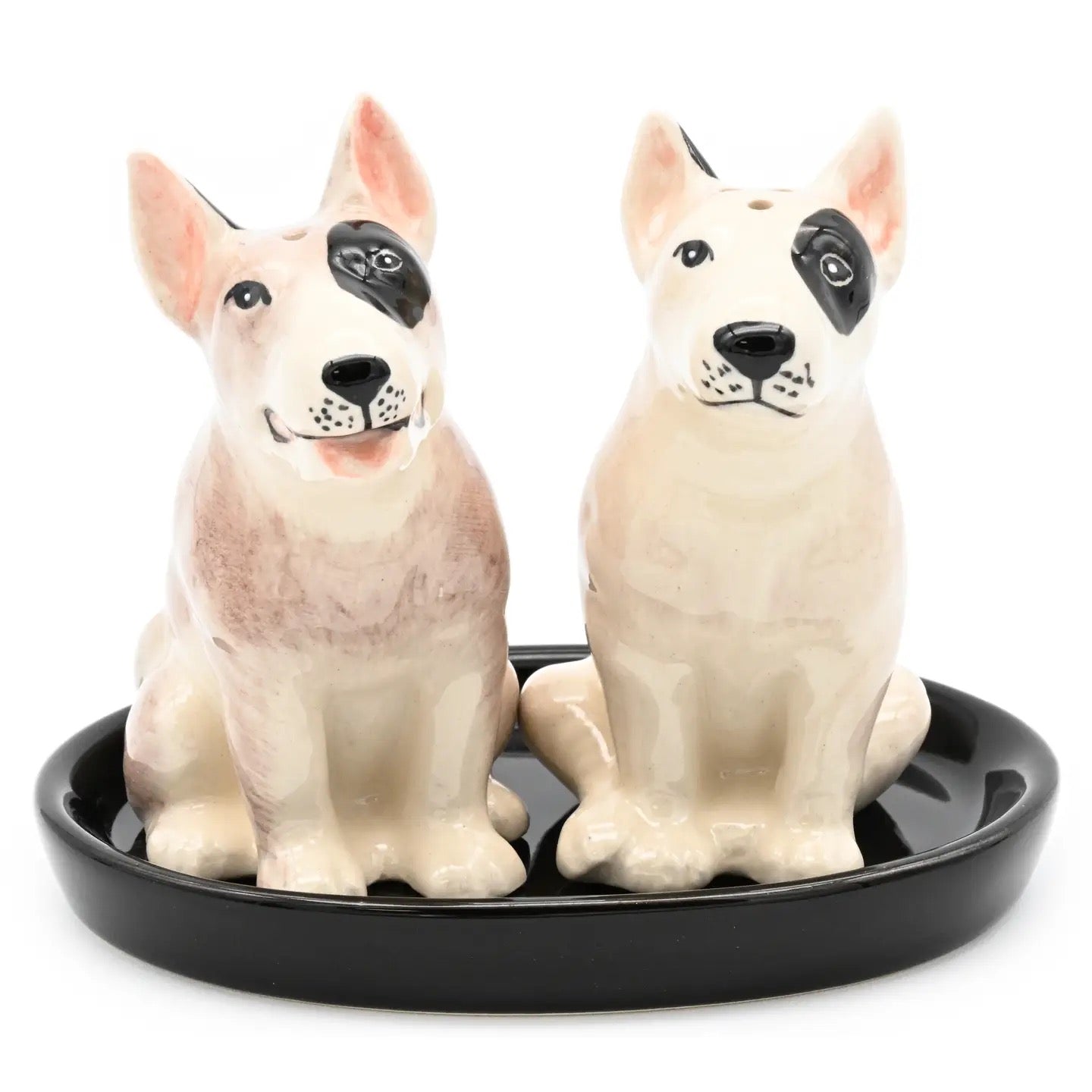Two ceramic dog figurines on a black tray with a white background
