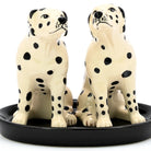 Two ceramic Dalmatian dog figurines on a black base against a white background