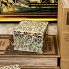 Decorative box with a speckled pattern on top of vintage books