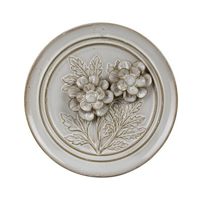 Decorative round panel with floral design on a white background