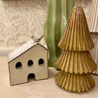 Ceramic house with a bird on top and a textured ceramic tree next to it.