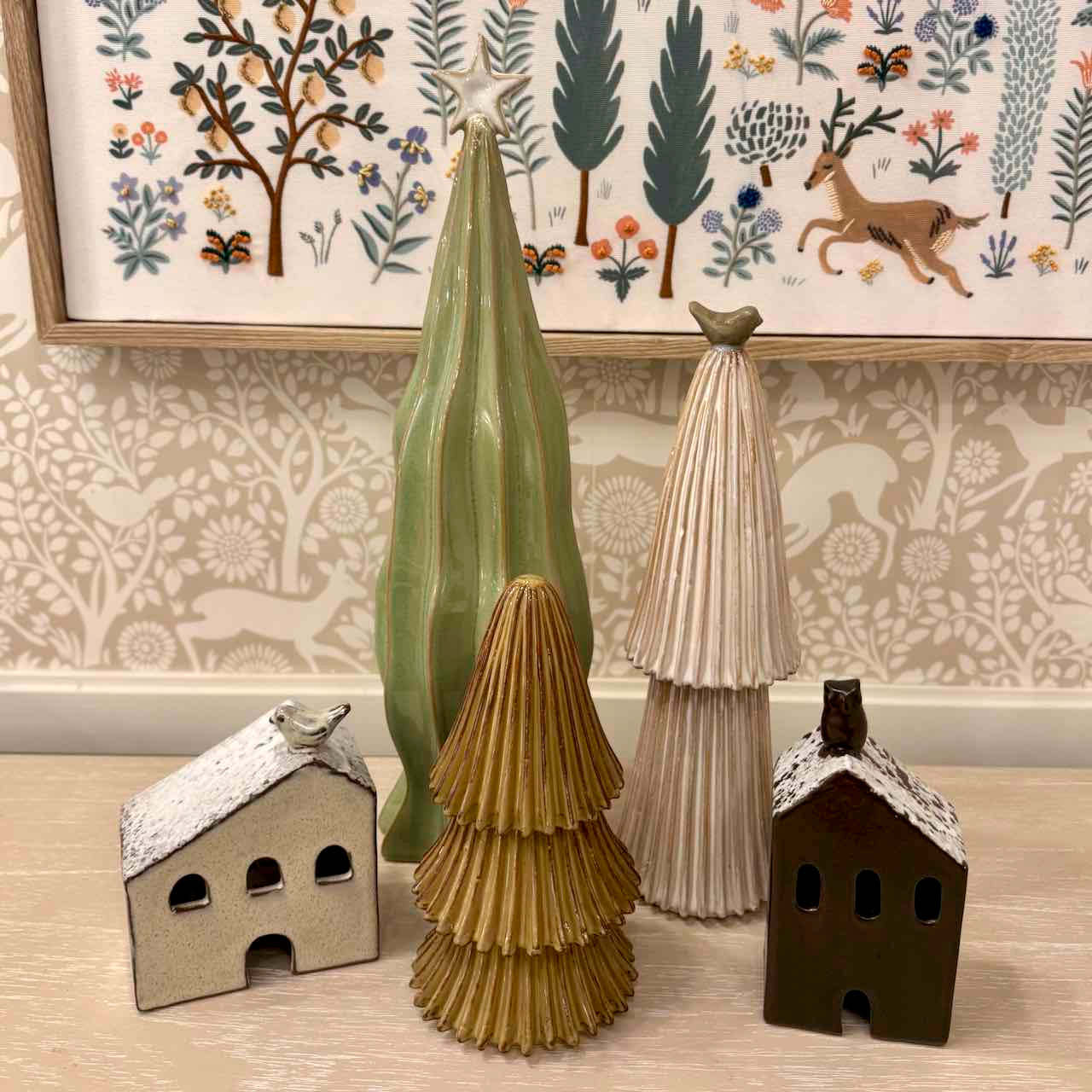 Decorative ceramic pieces on a wooden surface with a patterned wall in the background