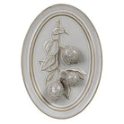 An oval wall plaque featuring a raised relief design of three textured oranges on a branch with leaves, finished in a light gray stone or plaster look with a warm beige border.
