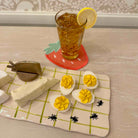 Deviled eggs with a glass of iced tea on a checkered tablecloth.