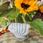 Sunflower in a decorative pot on a checkered floor