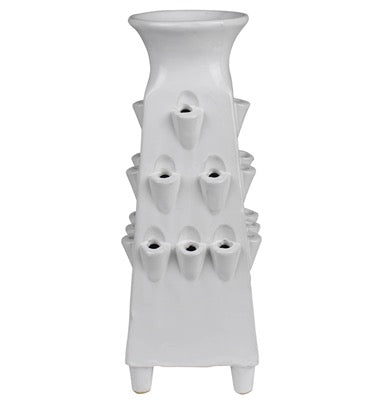 A white ceramic planter with a tiered design, featuring multiple small cup-like openings on the front that release water, set against a plain white background.