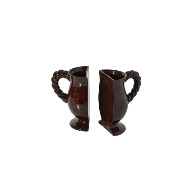 A pair of dark brown glossy ceramic pitchers with twisted rope handles, shown from opposite angles on a plain white background.