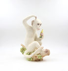 White ceramic monkey figurine holding a banana on a white background