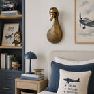 Decorative bedroom with airplane-themed pillows, books, and a lamp.