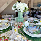 Easter-themed table setting with floral centerpiece, plates, and glasses.