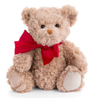 Beige teddy bear with a red bow on a white background
