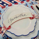White plate with 'Samantha' name tag on a decorative tablecloth with American flag pattern