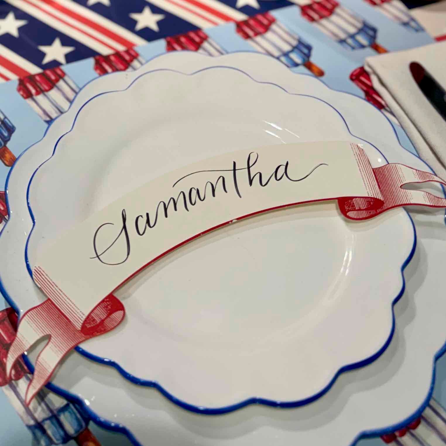 White plate with 'Samantha' name tag on a decorative tablecloth with American flag pattern