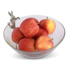 Clear glass bowl filled with red apples on a white background