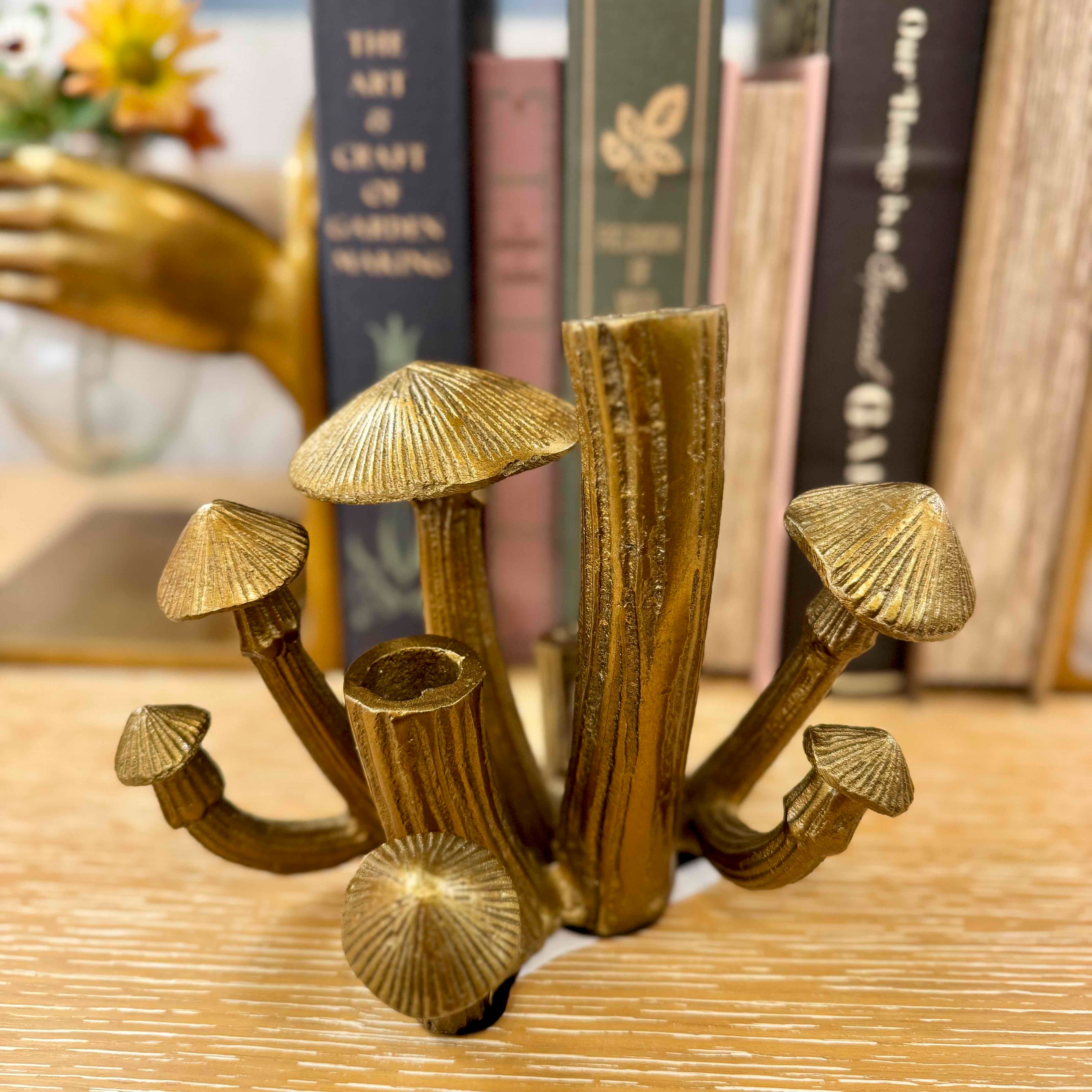 Bronze mushroom sculpture on a wooden surface with books in the background