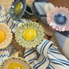 Decorative napkin rings with floral designs on a woven surface.