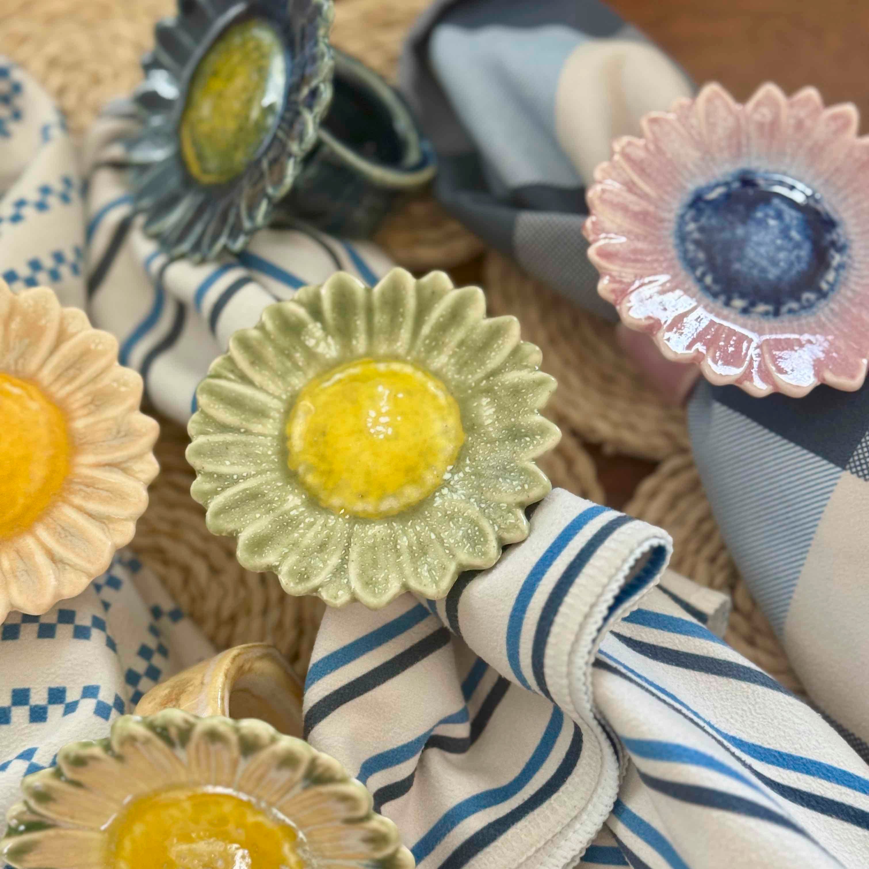 Decorative napkin rings with floral designs on a woven surface.