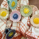 Decorative ceramic sunflowers on a woven surface with plaid fabric