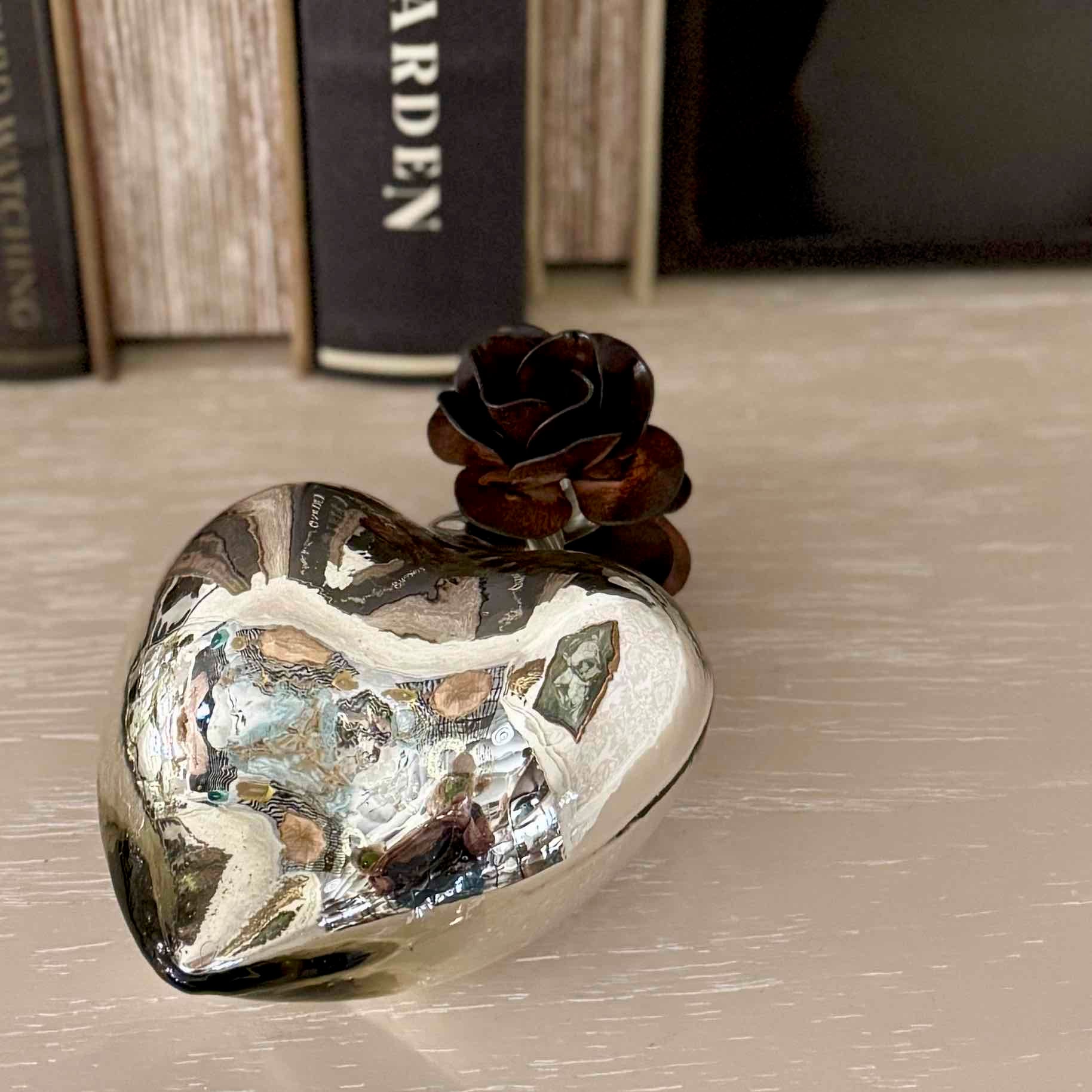 Heart-shaped decorative object with a rose on a textured surface