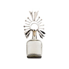 Decorative glass bottle with a metallic sunburst top on a white background