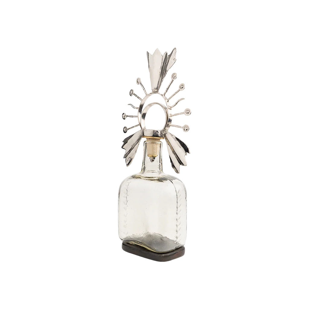 Decorative glass bottle with metallic top on a white background