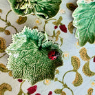 Decorative ceramic tiles with leaf and ladybug designs on a floral-patterned surface.
