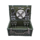 Green picnic basket with cutlery and plates on a white background