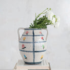 Decorative vase with floral patterns and flowers on a white background