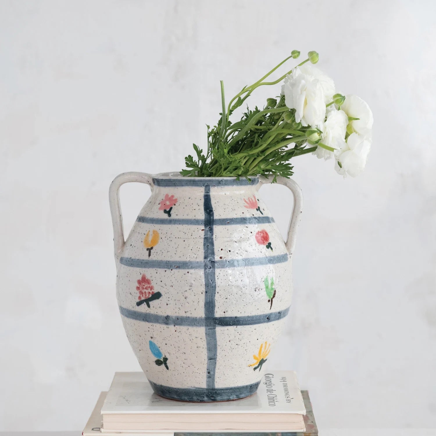 Decorative vase with floral patterns and flowers on a white background