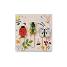 Set of four colorful paperclips with insect designs on a decorative card with flowers and leaves.
